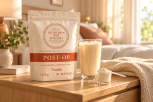 SurgiFuel Post-Op vanilla nutrition shake pouch on a bedside table at home with a glass of shake
